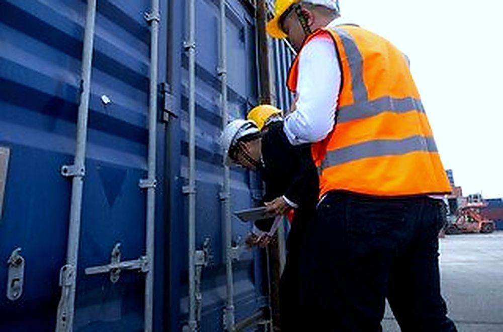 UAE customs clearance services — port workers inspecting shipping container Dubai