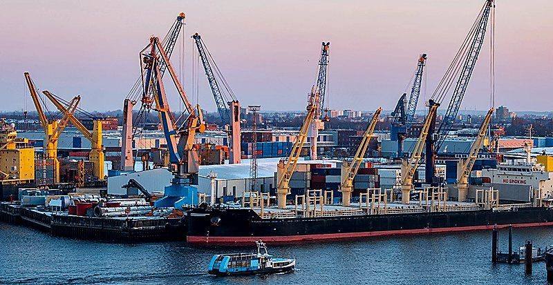Port cranes and break bulk cargo at sunset
